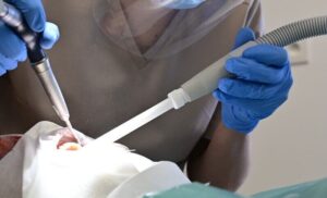 Higienistka stomatologiczna wykonuje profesjonalne czyszczenie zębów pacjenta przy użyciu specjalistycznych końcówek.